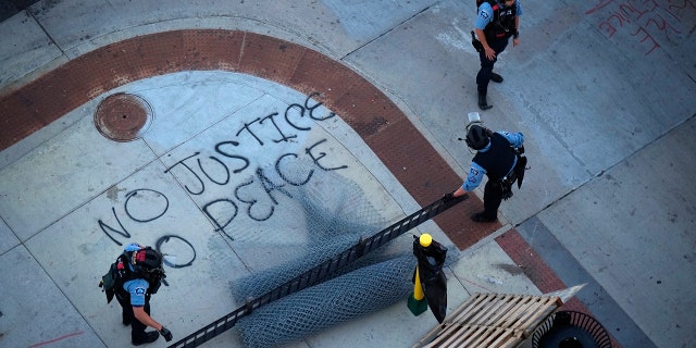 Minneapolis Police descend on the block long stretch of Lake St. just before sunset to dismantle the barricades erected by protesters in Minneapolis on June 15, 2021. Members of a U.S. Marshals Service task force will not be charged in the fatal shooting of Winston Smith Jr., a Black man who was killed while authorities were trying to arrest him as he sat in an SUV at a Minneapolis parking ramp. (Jeff Wheeler/Star Tribune via AP File)