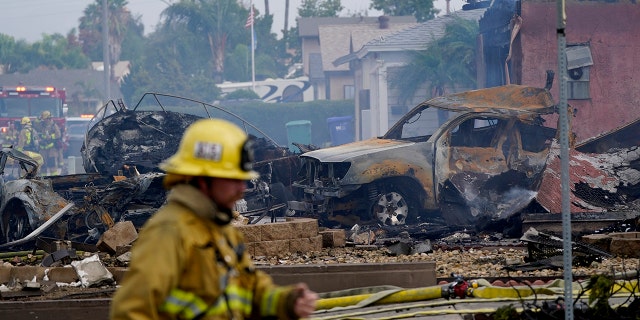 تعمل فرق الإطفاء في موقع حادث تحطم طائرة صغيرة ، يوم الاثنين 11 أكتوبر 2021 ، في سانتي ، كاليفورنيا.
