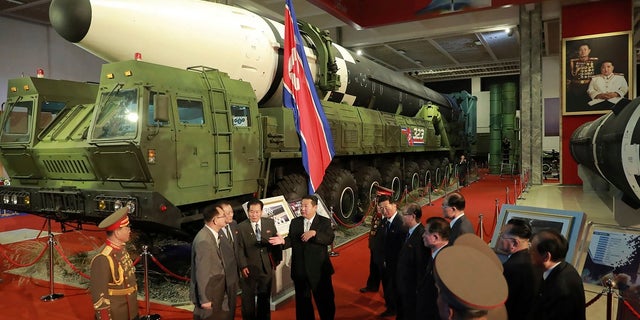 In this photo provided by the North Korean government, North Korean leader Kim Jong Un, center, speaks in front of what the North says an intercontinental ballistic missile displayed at an exhibition of weapons systems in Pyongyang, North Korea on Monday.