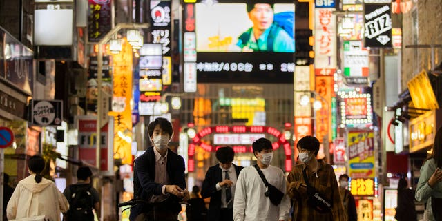 DOSSIER – Dans cette photo d'archive du 1er octobre 2021, des gens marchent dans le célèbre quartier des divertissements de Kabukicho à Tokyo la première nuit de la levée par le gouvernement de l'état d'urgence contre les coronavirus. Presque du jour au lendemain, le Japon est devenu une réussite étonnante et quelque peu mystérieuse de coronavirus. Le nombre de cas est en baisse, mais les experts craignent que, sans savoir exactement comment cela a réduit les cas de manière aussi drastique, la nation pourrait être en réserve pour une autre vague dévastatrice comme pendant l'été. (AP Photo/Hiro Komae, dossier)