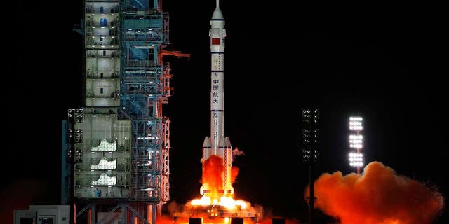In this photo released by Xinhua News Agency, the crewed spaceship Shenzhou-13, atop a Long March-2F carrier rocket, is launched from the Jiuquan Satellite Launch Center in northwest China's Gobi Desert, Oct. 16, 2021. 