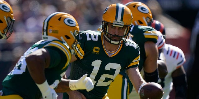 Green Bay Packers quarterback Aaron Rodgers (12) handing the ball off to running back A.J. Dillon Oct. 17 in Chicago.