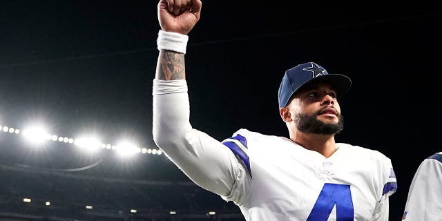 O quarterback do Dallas Cowboys, Dak Prescott, lança seu punho em direção aos fãs após sua vitória na prorrogação sobre o New England Patriots após um jogo de futebol americano da NFL, domingo, 17 de outubro de 2021, em Foxboro, Massachusetts.  (AP Photo / Steven Senne)