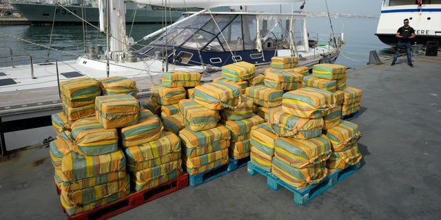 Bales of cocaine weighting some 5.2 tons and a seized yacht are displayed for the media at a Portuguese Navy base in Almada, south of Lisbon, Monday, Oct. 18, 2021.  (AP Photo/Armando Franca)