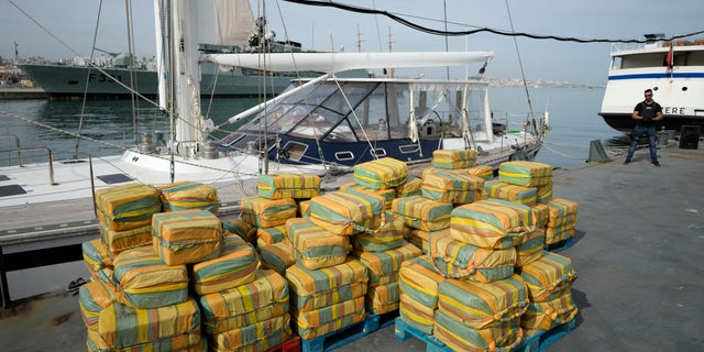 Bales of cocaine weighting some 5.2 tons and a seized yacht are displayed for the media at a Portuguese Navy base in Almada, south of Lisbon, Monday, Oct. 18, 2021.  (AP Photo/Armando Franca)