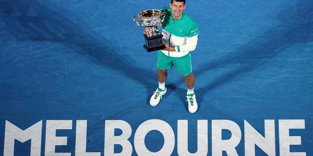 Serbia's Novak Djokovic holds the Norman Brookes Challenge Cup after defeating Russia's Daniil Medvedev in the men's singles final at the Australian Open tennis championship in Melbourne, Australia.