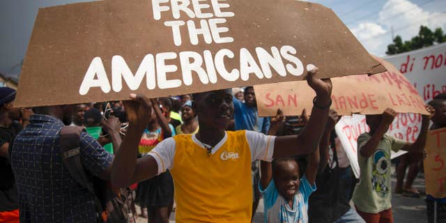 People protest for the release of kidnapped missionaries near the Ohio-based Christian Aid Ministries headquarters in Titanyen, north of Port-au-Prince, Haiti, Tuesday, Oct. 19, 2021.  (AP Photo/Joseph Odelyn)