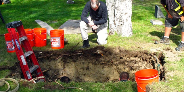 CORRECTS VICTIM'S NAME TO ROBIN PELKEY, INSTEAD OF HARRIET ROBIN PELKEY - FILE - In this Sept. 3, 2014, file photo, workers and medical examiner crew members exhume the body of Jane Doe #3 from a cemetery in Anchorage, Alaska. The remains of a woman known for 37 years only as Horseshoe Harriet, one of 17 victims of a notorious Alaska serial killer, have been identified through DNA profiling as Robin Pelkey, authorities said Friday, Oct. 22, 2021. (AP Photo/Rachel D'Oro, File)