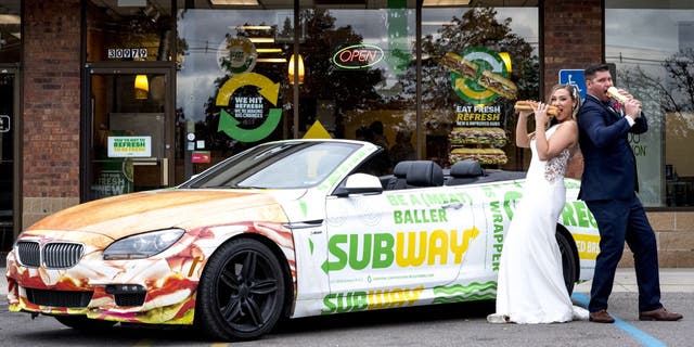 Julie Bushart  and Zack Williams posed outside the Subway where they first met each other in 2017 with a Subway-themed convertible sports car and foot-long sandwiches.