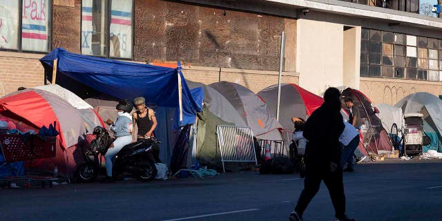 The tents of a homeless camp line the sidewalk in area commonly known as Mass and Cass, Saturday, Oct. 23, 2021, in Boston. 