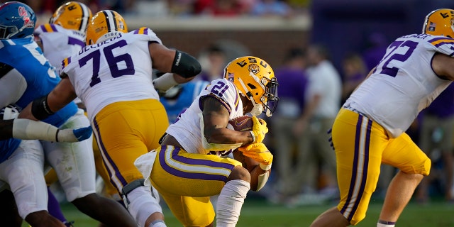 LSU running back Corey Kiner (21) attempts to run upfield during the first half of an NCAA college football game against Mississippi in Oxford, Miss., Saturday, Oct. 23, 2021. Mississippi won 31-17. (AP Photo/Rogelio V. Solis)