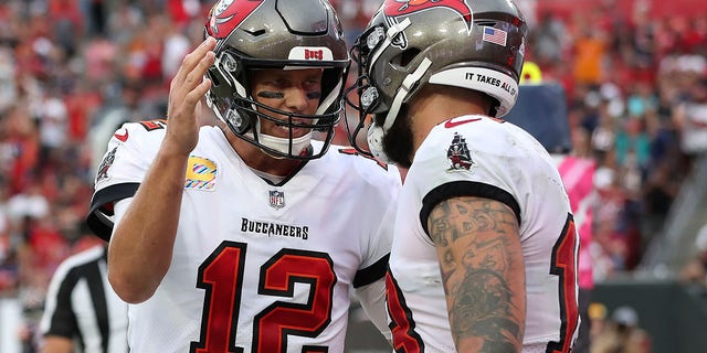 Tampa Bay Buccaneers quarterback Tom Brady (12) celebrates with wide receiver Mike Evans (13) after Evans caught a touchdown pass during the first half of an NFL football game against the Chicago Bears Sunday, Oct. 24, 2021, in Tampa, Florida.