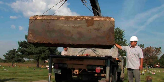 In this undated file photo provided by the Cook County Sheriff's Office, authorities exhume a box with the remains of unidentified victims of serial killer John Wayne Gacy, who was convicted of killing 33 young men and boys in the Chicago area in the 1970s.