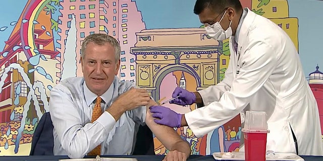 In this image from video, New York Mayor Bill de Blasio, left, receives a COVID-19 Moderna vaccine booster from New York City Health Commissioner Dr. Dave Chokshi, during the mayor's daily news briefing, Monday, Oct, 25, 2021. New York Gov. Kathy Hochul and Mayor Bill de Blasio each received COVID-19 boosters Monday as part of their efforts to promote widespread vaccinations. (Office of the New York Mayor via AP)