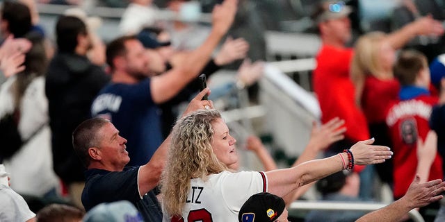 In this  April 2021 file photo, Atlanta Braves fans do the Tomahawk Chop during a game against the Philadelphia Phillies in Atlanta.