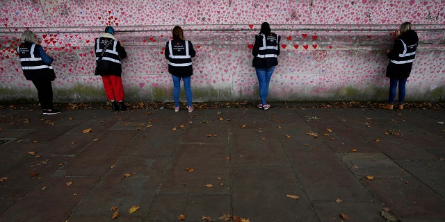 Volunteers work on the COVID-19 Memorial Wall in Westminster in London on Friday, October 15, 2021.