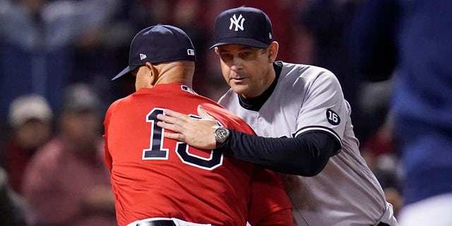 New York Yankees manager Aaron Boone, right, greets Boston Red Sox manager Alex Cora before an American League Wild Card baseball game at Fenway Park on Tuesday, October 5, 2021, in Boston.