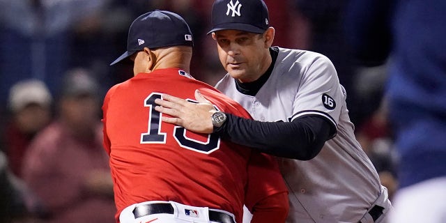 New York Yankees manager Aaron Boone, right, greets Boston Red Sox manager Alex Cora before an American League Wild Card baseball game at Fenway Park, Tuesday, Oct. 5, 2021, in Boston.