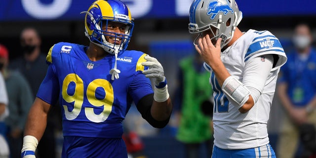 O quarterback do Detroit Lions, Jared Gough, à direita, fala com o defensor do Los Angeles Rams Aaron Donald durante a primeira metade de um jogo de futebol americano da NFL no domingo, 24 de outubro de 2021 em Inglewood, Califórnia.