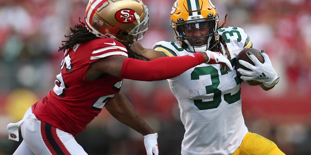 Green Bay Packers running back Aaron Jones (33) runs against San Francisco 49ers cornerback Josh Norman during the first half of an NFL football game in Santa Clara, Calif., Sunday, Sept. 26, 2021.