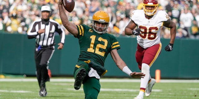 Green Bay Packers' Aaron Rodgers runs for a first down against Washington Sunday, Oct. 24, 2021, in Wisconsin.