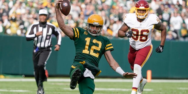 Green Bay Packers' Aaron Rodgers runs for a first down during the first half of an NFL football game against the Washington Football Team Sunday, 10 월. 24, 2021, 그린 베이, 위스콘신.