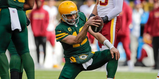 Aaron Rodgers do Green Bay Packers comemora seu primeiro touchdown durante a primeira metade de um jogo de futebol americano da NFL contra o Washington FC no domingo, 24 de outubro de 2021, em Green Bay, Wisconsin.