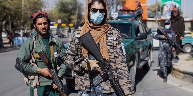 Taliban fighters stand guard during women's protest in Kabul, Afghanistan, Thursday, Oct. 21, 2021. (AP Photo/Ahmad Halabisaz)