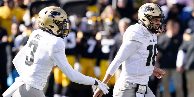 Purdue quarterback Aidan O'Connell (16) celebrates with wide receiver David Bell (3) after scoring on a 6-yard touchdown run during the first half of a game against Iowa, Saturday, Oct. 16, 2021, in Iowa City, Iowa.
