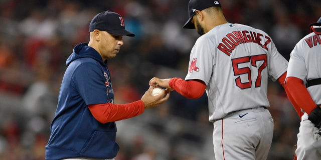 Boston Red Sox manager Alex Cora, left, pulls starting pitcher Eduardo Rodriguez (57) during the sixth inning of a baseball game against the Washington Nationals, Friday, Oct. 1, 2021, in Washington.