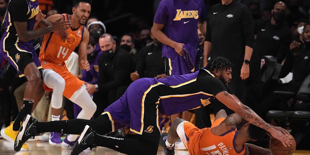 Oct 22, 2021; Los Angeles, California, USA; Los Angeles Lakers forward Anthony Davis (3) and Phoenix Suns guard Cameron Payne (15) battle for the ball in the first half at Staples Center.