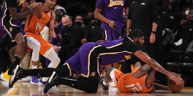 Oct 22, 2021; Los Angeles, California, USA; Los Angeles Lakers forward Anthony Davis (3) and Phoenix Suns guard Cameron Payne (15) battle for the ball in the first half at Staples Center.