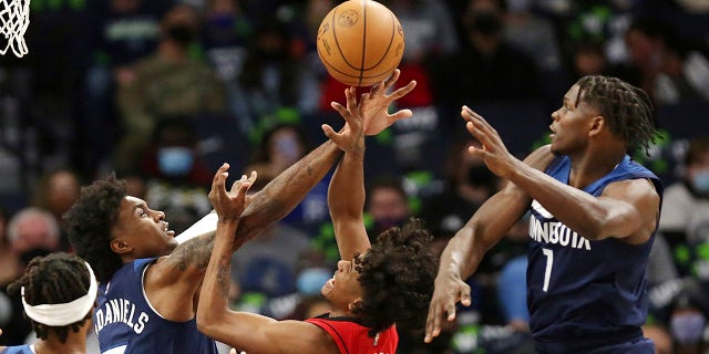 Houston Rockets guard Jalen Green (0) has a shot blocked by Minnesota Timberwolves forward Jaden McDaniels (3) with defense from Timberwolves forward Anthony Edwards (1) oct. 20 en Minneapolis.