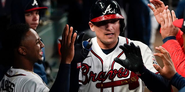 Atlanta Braves' Austin Riley is congratulated after hitting a home run in the fourth inning in Game 1 of baseball's National League Championship Series against the Los Angeles Dodgers Saturday, Oct. 16, 2021, in Atlanta.