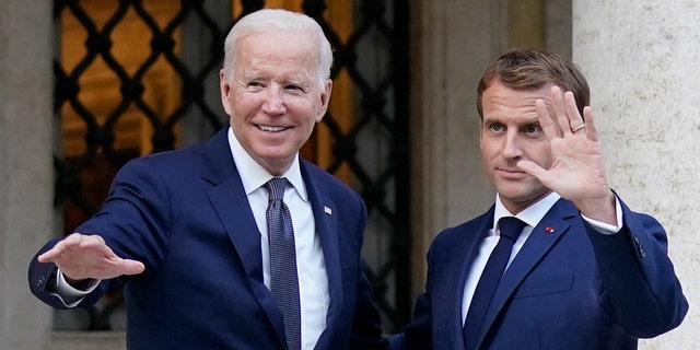 U.S. President Joe Biden, left, and French President Emmanuel Macron wave prior to a meeting at La Villa Bonaparte in Rome, Friday, Oct. 29, 2021.