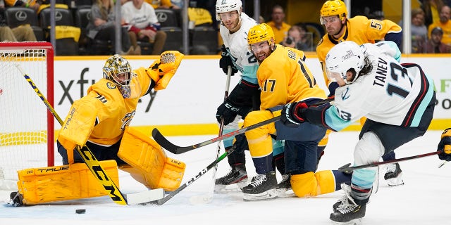 Seattle Kraken left wing Brandon Tanev (13) scores a goal against Nashville Predators goaltender Juuse Saros (74) in the first period of an NHL hockey game Thursday, 十月. 14, 2021, 在纳什维尔, 天恩.