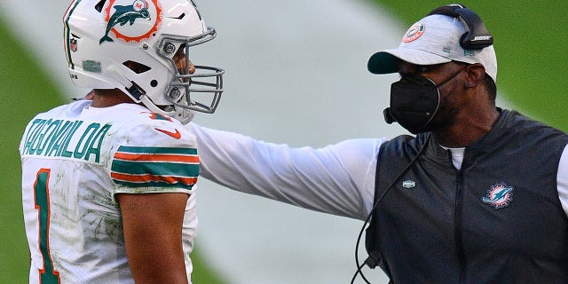 Head Coach Brian Flores of the Miami Dolphins speaks with Tua Tagovailoa #1 during the game against the Los Angeles Chargers at Hard Rock Stadium on Nov. 15, 2020 in Miami Gardens, Florida.