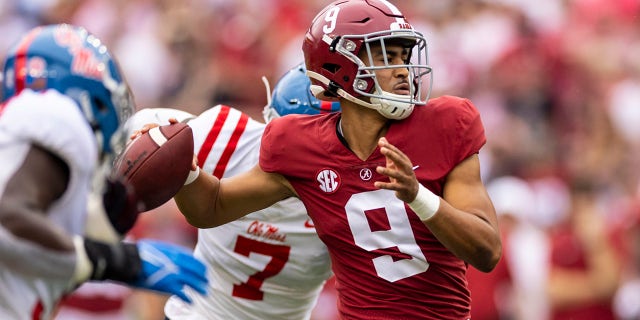 El mariscal de campo de Alabama Bryce Young (9) Lanza un pase de touchdown bajo presión de Mississippi durante la primera mitad de un juego de fútbol americano universitario de la NCAA, sábado, oct. 2, 2021, en Tuscaloosa, Ala.