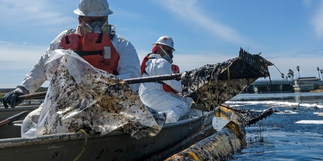 FILE - On this Sunday October 3, 2021, file photo, cleaning contractors deploy skimmers and floating barriers known as booms in an attempt to stop a new incursion of crude oil into the Talbert Marsh wetlands in Huntington Beach, California after a Southern California oil spill. Finding out the cause of the spill, who is to blame and whether they will be held responsible can be time consuming.