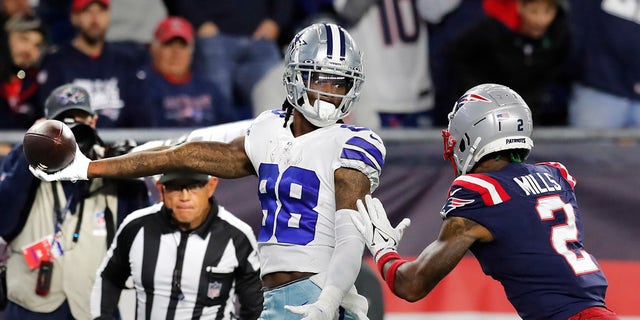 Dallas Cowboys wide receiver CeeDee Lamb (88) stretches the ball over the goal line for the game-winning touchdown as New England Patriots cornerback Jalen Mills (2) gives chase during overtime of an NFL football game, Sunday, Oct. 17, 2021, in Foxborough, Massachusetts.