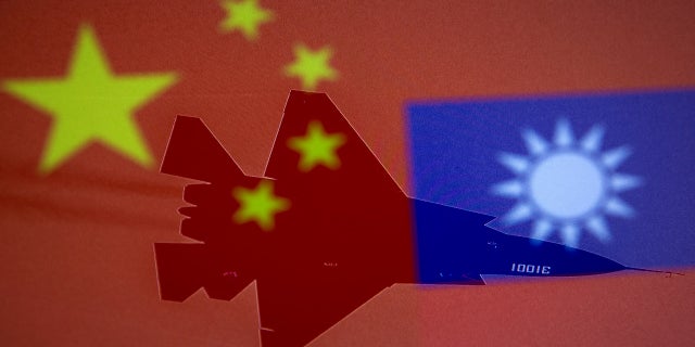Chinese and Taiwanese national flags are displayed alongside a military airplane in this illustration taken April 9. (Reuters)