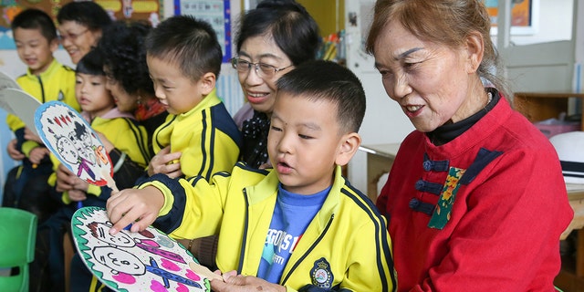 Children give handmade fans to their grandparents in a kindergarten of Lianyungang City, east China's Jiangsu Province in October. A proposed law in China would punish parents or guardians if their children misbehaved.