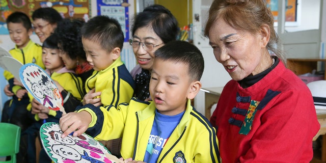 Children give handmade fans to their grandparents in a kindergarten of Lianyungang City, east China's Jiangsu Province in October. A proposed law in China would punish parents or guardians if their children misbehaved.