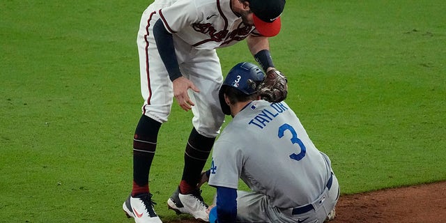 Los Angeles Dodgers' Chris Taylor (3) is tagged out by Atlanta Braves shortstop Dansby Swanson after being caught in a run down on base hit by Dodgers' Cody Bellinger during the ninth inning in Game 1 of baseball's National League Championship Series Saturday, Oct. 16, 2021, in Atlanta.