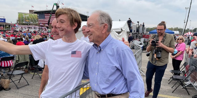 A young supporter takes a selfie with Sen. Chuck Grassley of Iowa, at former President Trump's rally in Des Moines, Iowa on Oct. 9, 2021.