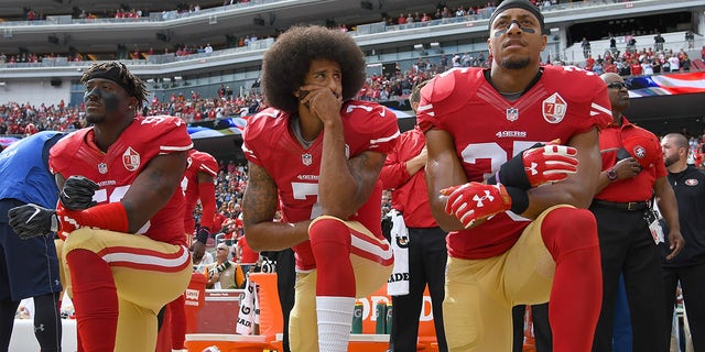 Colin Kaepernick #7 and Eric Reid #35 of the San Francisco 49ers kneel on the sideline during the National Anthem prior to the game against the Dallas Cowboys at Levi's Stadium on October 2, 2016, in Santa Clara, California. 