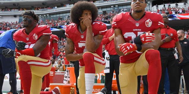 Colin Kaepernick #7 and Eric Reid #35 of the San Francisco 49ers kneel on the sideline during the National Anthem prior to the game against the Dallas Cowboys at Levi's Stadium on October 2, 2016, in Santa Clara, California. 