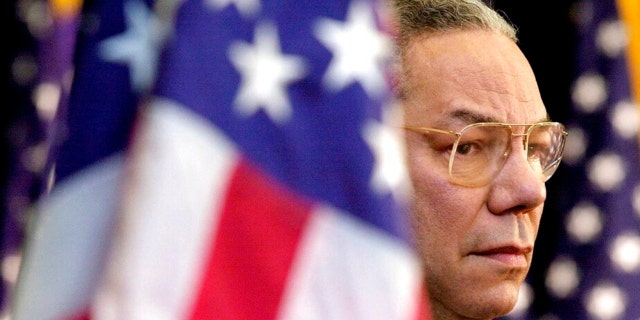 在这个二月. 15, 2001 档案照片, Secretary of State Colin Powell looks on as President Bush addresses State Department employees at the State Department in Washington.