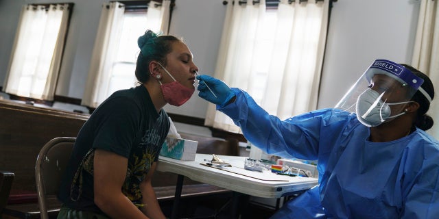 Jessica Leo, left, is tested for COVID-19 at a clinic set up at Bethel AME Church on Sept. 24, 2021, in Providence, Rhode Island.