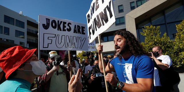 A counter protester talks with a demonstrator at a rally in support of the Netflix transgender employee walkout 